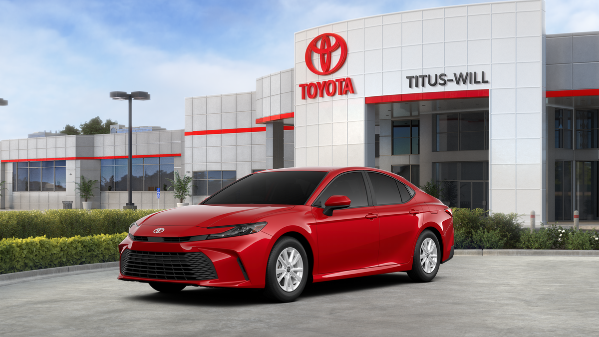 2026 Toyota Camry LE in Supersonic Red — front three-quarter view